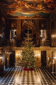 a christmas tree in the middle of a room with paintings on the walls and ceiling