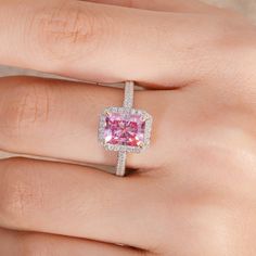 a woman's hand with a pink and white diamond ring