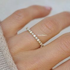 a woman's hand with a diamond ring on top of her finger and the bottom half