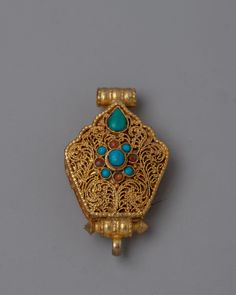 an antique gold brooch with turquoise stones and filigrees