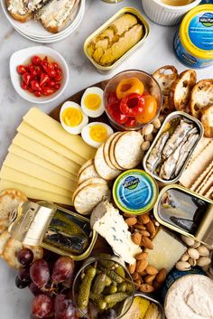 an assortment of cheeses, crackers and other foods