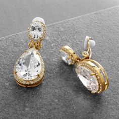 Clip On Gold Plated CZ Wedding Earrings These glamorous 14K gold plated bridal earrings feature pave framed cz ovals with a stunning pear shaped cz drop. These clip-on style gold plated wedding earrings with glistening AAA quality cz crystals are guaranteed to make a bold statement for the bride, bridesmaids or mother of the bride. Size: 1 1/2" long. Color: Gold. Style: 2074E-G. Available in clip on style only. Lots of sparkle! Need several pair of earrings for your bridesmaids? You can buy in bulk and save! Please allow 1 week for delivery. Shipping Policy . Return Policy Earring For Bride, Brides Jewelry, Jewelry For Wedding, Wedding Mother Of The Bride, Silver Bridal Earrings, Formal Earrings, Bridesmaid Pearls, Pearl Jewelry Wedding, Gold Headband