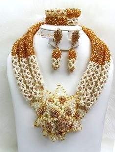 White with Gold infused Beautiful 3 layers Handmade Nigerian Beads Jewellery Celebrant Bridal Set Complete Set is Necklace, bracelet & Earring. It comes with 2 styles of earring. You can customise it the style to your specification ie colour, layers and accessories.  Wedding Party Bridal Special Occasion This detailed Jewellery set makes you stand out elegantly in any special occassion, it's all about glamour and uniqueness.  Buying more that 1 Jewellery set, we offer wholesale and bulk prices f White Beaded Jewelry Sets For Celebration, White Beads With Gold Details For Celebration, White Faceted Beads Jewelry For Celebration, White Beaded Necklace With Colorful Beads For Weddings, Large Gold Pearl Beads, Elegant White Jewelry Set With Gold Beads, White Beaded Necklaces With Colorful Beads For Weddings, Yellow Pearl Wedding Jewelry, White Jewelry With Colorful Beads For Celebration