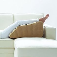 a woman is laying on the couch with her feet propped up against the armrest