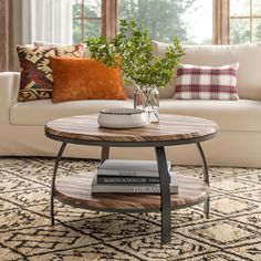 a living room with a couch, coffee table and pillows on the floor in front of it