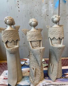 three ceramic sculptures sitting on top of a table