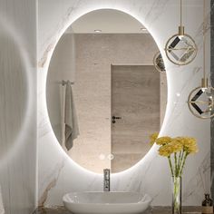 a white sink sitting under a round mirror