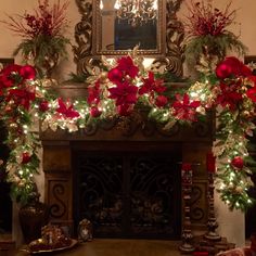 a fireplace decorated for christmas with red poinsettis and greenery