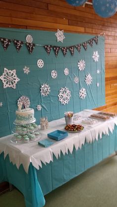 a table covered in snowflakes and desserts for a winter themed birthday party