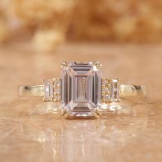 an emerald cut diamond ring with three side stones