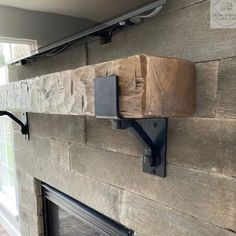 a fireplace with some wood on the mantle and a tv above it that is mounted to the wall