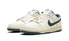 The Nike Dunk Low "Athletic Department - Deep Jungle" is a colorway of the retro basketball sneaker with a vintage college sports aesthetic.  The upper features a Sail leather construction with a Deep Jungle-colored suede Swoosh that matches the appearance of the heel tab with “Nike” embroidery.  Classic “Nike” detailing can be seen on the tongue.  More Deep Jungle accenting includes a green lining, and green rubber outsole underneath the rubber midsole.  A special “Nike Athletic Department” logo is found on each insole.  Release date: October 1, 2023 Vintage Nike Shoes Aesthetic, Nike Shoes Green, Shoes Nike Dunks, Vintage Nike Shoes, Green Nike Shoes, Nike Embroidery, Deep Jungle, Sneakers Box, Kobe Shoes