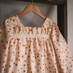 a dress hanging on a wooden hanger