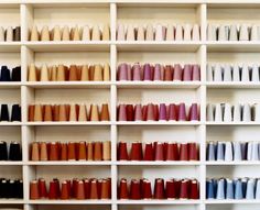 the shelves are filled with different colored vases