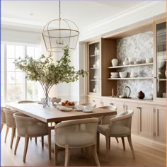 a dining room table with chairs and plates on it