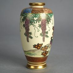 a vase with grapes painted on it sitting on a table