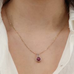 Add a touch of glamour to your neckline with this exquisite Ladies 14k Yellow Gold Fine Chain Ruby and Diamond Necklace. The delicate 21-inch fine chain, with a width of 1.25mm, secures gracefully with a Spring Ring closure. The centerpiece of this necklace is a vibrant round-cut ruby, estimated at 1.1ct, radiating a rich hue. Surrounding the ruby are 37 dazzling round brilliant-cut diamonds, each weighing 0.01ct, with a total carat weight of 0.37ctw. The diamonds exhibit a color range of J-I an Fine Jewelry Birthstone Necklace With Delicate Chain, Delicate Chain Pendant Birthstone Necklace, Formal Round Birthstone Necklace With Delicate Chain, Classic Yellow Gold Birthstone Necklace With Delicate Chain, Elegant 14k Gold Oval Chain Necklace, Elegant Oval 14k Gold Chain Necklace, 14k Gold Birthstone Necklaces, Gold Birthstone Necklaces, Formal Birthstone Necklace With Diamond Cut