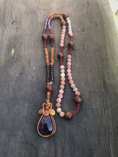 I created this collection of necklaces that I called Malasana, in honor to the Art of Yoga. Each piece of jewelry has a main semiprecious stone beautifully worked with copper. The stones are high quality and they come from South America. They are accompanied by 108 pearls and sometimes by micro macramé knots. Here you have a necklace in violet/purple tones with Amethyst, Mahogany Obsidian, Citrine, Garnet, Rudraksha and Jasper.  The pendant is a good looking Amethyst, one of the main stones of the new Aquarius Age. It is an extremely powerful and protective stone with a spiritual vibration.  I wrote a lot about stones on my other listings. I strongly encourage you to read about stones and crystals and feel which quality works best for you. Crystals are our friends. The length mentioned is Bohemian Necklaces With Stones For Meditation, Holistic Stones Jewelry For Meditation, Meditation Necklaces With Round Beads And Stones, Spiritual Gemstone Beaded Necklaces For Jewelry Making, Handmade Spiritual Beads For Jewelry Making, Artisan Adjustable Crystal Necklace With Stones, Spiritual Necklaces With Natural Stones For Jewelry Making, Spiritual Hand Wrapped Necklaces With Round Beads, Spiritual Gemstone Necklace