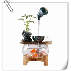 a fish bowl filled with goldfish under a faucet on top of a table