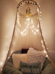 a canopy bed with lights on the ceiling and a pillow in front of it that says wake up and work out