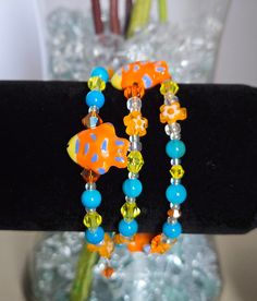 This bracelet is uniquely handmade. It includes semi precious stone blue striped agate, Yellow, orange and white swvarski crystals, porcelain fish, czech flower beads, matching glass beads, and custom czech and crystal charms. This is an easy-to-wear bracelet with no clasp just wrap around your wrist. This bracelet is made to fit most wrists because there is no clasp making it adjustable to each individual wrist. This would be a wonderful gift for yourself or others. Memory Wire Cuff Bracelet, Wire Cuff Bracelet, Fish Ocean, Yellow Agate, Wire Cuff, Ocean Theme, Great Falls, Memory Wire Bracelets, Flower Beads