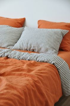 an orange and white bed with two pillows