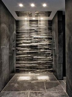 a very nice looking bathroom with some lights on the ceiling and stone wall behind it