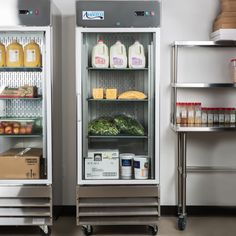 two refrigerators filled with food sitting next to each other on metal shelves in a kitchen