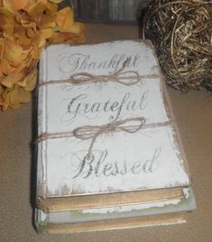 a book that is sitting on a table next to some flowers and twine balls