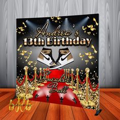 a black and gold masquerade birthday sign with red carpet on wooden flooring