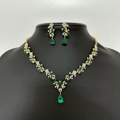 💚 Emerald Green Crystal Jewelry Set - Gold Wedding Necklace Set for Brides. Absolutely Stunning emerald bridal necklace and matching earrings set!   💚 Luxury Wedding Pendant encrusted with gold-colored chains, and rhinestones. This green jewelry set is perfect for your special day! Includes stunning necklace, and earrings beautifully crafted into a gold setting. Combined with many clear crystals and rhinestones!   💚 This wedding necklace set is an elegant and timeless must-have for the woman Emerald Green Necklace Set, Emerald Wedding Jewelry Set, Green Crystal Bridal Earrings For Wedding, Gold Bride Jewelry Set, Gold And Emerald Necklace, Green Jewellery Set, Emerald Jewelry Set, Emerald Green Jewelry, Green Quinceanera