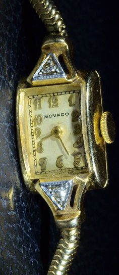 Remarkable Ladies Vintage Yellow Gold Movado Watch with Diamonds. The Arabic numbers are Art Deco in style and the watch is a wonderful example of an antique Movado. Perfect for everyday wear or that evening out. This watch is 6 inches long. Each piece has been hand selected and meticulously identified and graded by a Graduate Gemologist who has been awarded a degree by the Gemological Institute of America (GIA). Please visit our Shop's About Page or our website for more information about our je Vintage Diamond Watch With Rectangular Dial, Vintage Jewelry And Watches With Diamond Hour Markers, Vintage Diamond Watch With Rectangular Dial For Formal Events, Vintage Diamond Watch With Rectangular Dial For Formal Occasions, Vintage Watches With Diamond Hour Markers As Gift, Vintage Watch Accessories With Diamond Hour Markers As Gift, Vintage Yellow Gold Watches With Diamond Hour Markers, Antique Yellow Gold Watch For Evening, Elegant Collectible Watch With Rectangular Dial