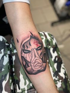 a man's arm with a tattoo on it that has a face in the middle