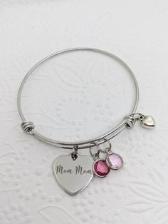 "This is a stainless steel bangle with an 18mm mirror polished stainless steel heart charm, that reads, \"Mom Mom.\" The bracelet is also adorned with the 8mm glass crystal birthstone charms of your choosing. To order: Choose the number of birthstones from the drop down boxes. Then write the MONTHS in the order you would like them in the personalization box. Color options are in the second photo. Some months have multiple options, so please write the choices as they are labelled. All items arriv Customizable Metal Jewelry For Mother's Day, Heart Shaped Stainless Steel Jewelry For Mother's Day, Customizable Stainless Steel Jewelry For Mother's Day, Mother's Day Personalized Stainless Steel Jewelry, Mother's Day Metal Jewelry Gift For Mom, Personalized Stainless Steel Jewelry For Mother's Day, Personalized Hypoallergenic Stainless Steel Jewelry, Custom Name Stainless Steel Jewelry For Anniversary, Hypoallergenic Stainless Steel Jewelry For Personalized Gifts