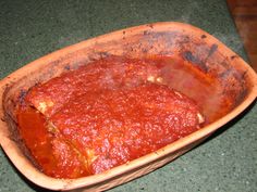 a square dish filled with sauce on top of a green counter