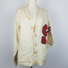 Vintage Varsity Letterman Cardigan Sweater. Cream/Ivory in color with Large 'S' Patch, 2 Arm Stripes on left arm, one is black and one stripe is red. There are areas of stains and discoloration, that I have not tried to remove. Unfortunately the bottom button is broken, the piece that came off I will put inside the pocket. Tiny tear near buttons. Made by Wilson Athletic Wear, Wilson Sporting Goods in the USA. Label states Men's size 40, COANE Philadelphia. As this is a vintage sweater, please ch Cream Cotton Sweater With Button Closure, Vintage Sweater With Pockets For Fall, Vintage Fall Sweater With Pockets, Cream Cotton Cardigan With Buttons, Retro White Sweater With Buttons, Vintage Button Closure Sweater For Fall, White Retro Sweater With Buttons, Vintage Button-up Sweater For Fall, Retro Cotton Sweater With Buttons