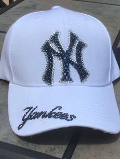 Check out these Ahhhhh-mazing Yankees hatsembellished with 100% authentic Swarovski crystal rhinestones These hats are a classic style ladies cut/fit, and have an adjustable velcro strap across the back. Choice of white or any colored hat. The white hat has navy blue stones with clear outline and the Yankees on the brim. The navy hat is made with all clear crystal and Yankees on the side of the hat I custom make these hats, and I can make them in just about any style or color combo. Please feel Rhinestone Baseball Cap One Size, Rhinestone Embellished One Size Baseball Cap, White Hats With Rhinestones And Curved Brim, Adjustable Baseball Cap With Bling, White Rhinestone Hat With Curved Brim, Adjustable Rhinestone Baseball Cap With Curved Brim, Adjustable Rhinestone Cap, Decorative Hats, Rhinestone Baseball Cap