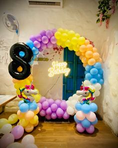 balloon arch with number 8 and balloons in front of the entrance to a birthday party