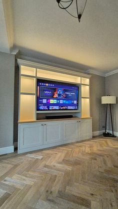 a flat screen tv sitting on top of a wooden entertainment center