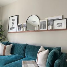 a living room filled with green couches and pictures on the wall above their head