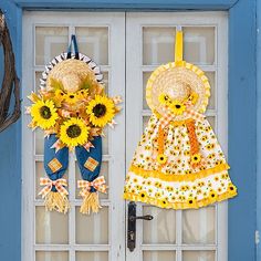 two scarecrows are hanging on the front door with sunflowers in them