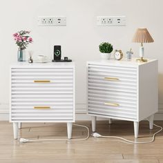 two white nightstands side by side with gold handles and knobs on the sides