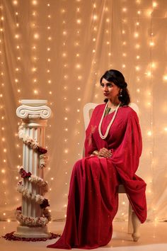 Reminiscent of the Bollywood divas of 1950s, the sarees in this collection aim at re living that timeless & elegant era, that is so close to the timelessness of Mukaish Embroidery. This Wine Coloured Saree is adorned with delicate embroidery of Flight of Pigeons (original Meiraas motif) on palla in a triangle flight pattern, while rest of the saree is covered with stars of Mukaish. NOTE: Mukaish is a Heritage Embroidery done by hand. This embroidery was initially done with Gold & Silver wires ones, but now is done with copper or even brass metal wires polished to gold & silver colour. For this embroidery following steps are taken: 1.)The wires are beaten to a thin thread like consistency first. 2.)A special Mukaish needle uses the beaten wires to make intricate patterns that are block prin Pre-draped Georgette Saree For Puja And Eid, Eid Celebration Pre-draped Saree, Bollywood Style Pre-draped Saree In Raw Silk, Chanderi Pre-draped Saree For Navratri, Festive Raw Silk Pre-draped Saree, Chanderi Cutdana Pre-draped Saree, Eid Chanderi Pre-draped Saree With Traditional Drape, Eid Chanderi Pre-draped Saree, Festive Pre-draped Chanderi Saree