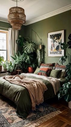 a bedroom with green walls and lots of plants in the corner, along with a large bed