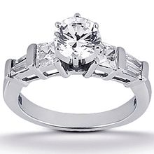 a white gold engagement ring with three stones on the side and two baguetts set in