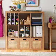 a wooden shelf filled with lots of books and crafting supplies on top of a hard wood floor