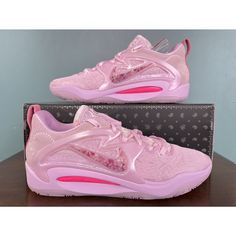 a pair of pink shoes sitting on top of a wooden table next to a box