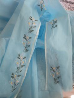 blue sheer fabric with embroidered flowers on it