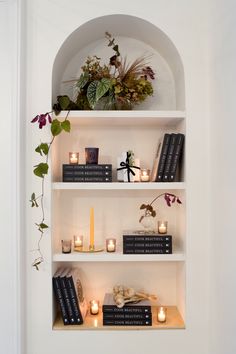 the shelves are filled with books and candles