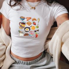 We love this fun, colorful Girl Breakfast Collage Baby Tee! This adult sized tee is soft and super comfy and is made of 52% cotton and 48% polyester for a luxurious lightweight stretch. The designs are printed with DTF which delivers a vivid, detailed design with a textured feel. This tee is a perfect blend of coquette fashion and nostalgic Y2K vibes, making it a trendy addition to your casual wardrobe. Made with soft, comfortable material, it's ideal for everyday wear or for making a statement Funny Print Graphic Tee Cropped T-shirt, Trendy Cropped T-shirt With Funny Print And Short Sleeves, Trendy Cropped T-shirt With Funny Print, Y2k Tops With Sublimation Print For Spring, Cute Cropped Cotton T-shirt, Printed Short Sleeve Tops For Brunch, Y2k Style Multicolor Short Sleeve T-shirt, 90s Style Crop Top T-shirt For Summer, Casual White Cropped T-shirt With Funny Print